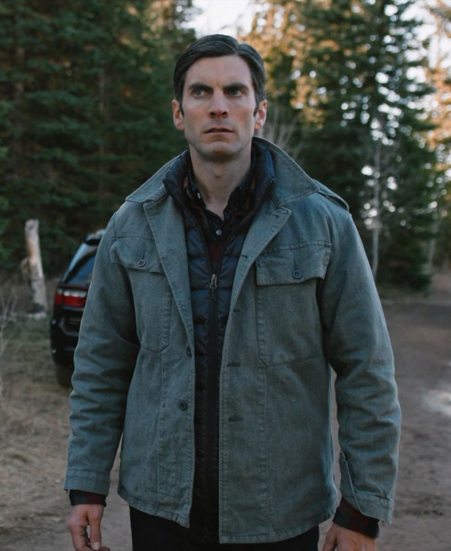 Jamie Dutton wearing a Grey Cotton jacket standing in a forested area with trees.