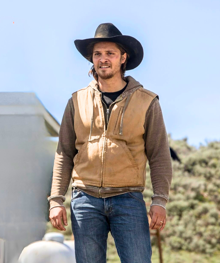 Man wearing a tan vest, brown shirt, blue jeans, and a black cowboy hat outdoors. yellowstone kayce dutton cotton vest