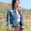 Woman wearing a denim jacket with embroidered designs in an outdoor setting full Image